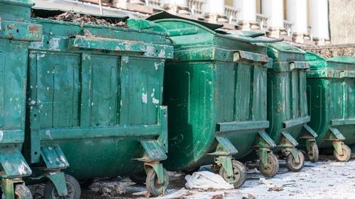 Row,Of,Large,Green,Metal,Dumpsters,With,Peeling,Paint,Lined